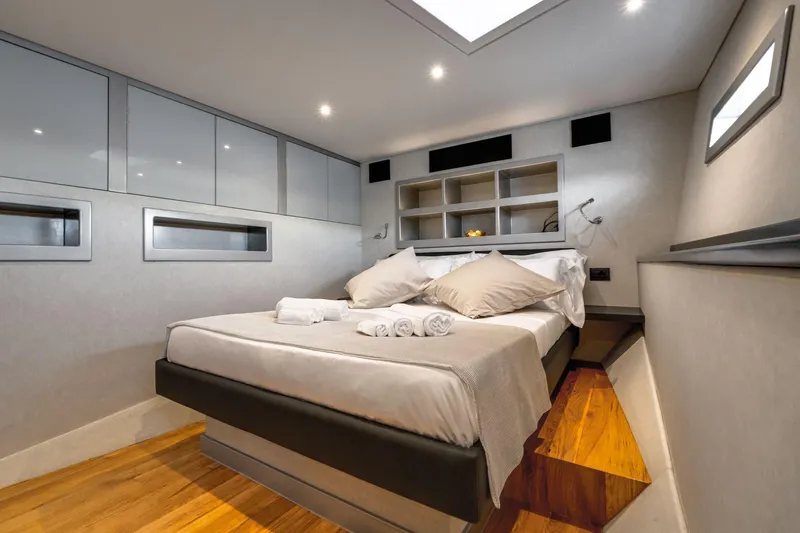 Lyfe At Sea Yacht Photos Pics Luxurious bedroom interior on 2015 Magic Yachts Custom, featuring modern design and cozy bedding.