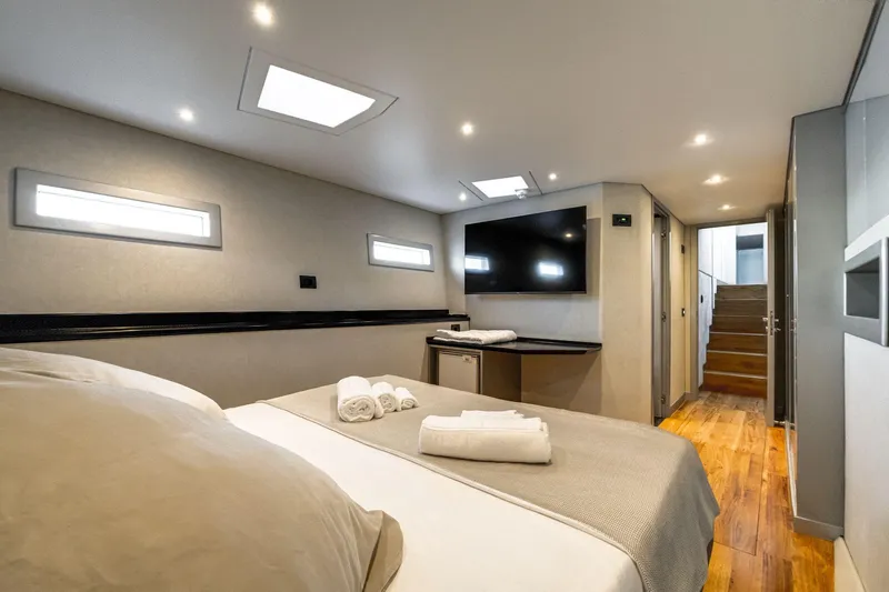 Lyfe At Sea Yacht Photos Pics Luxurious yacht bedroom interior with modern design, featuring a TV and elegant lighting. Magic Yachts Custom 2015.