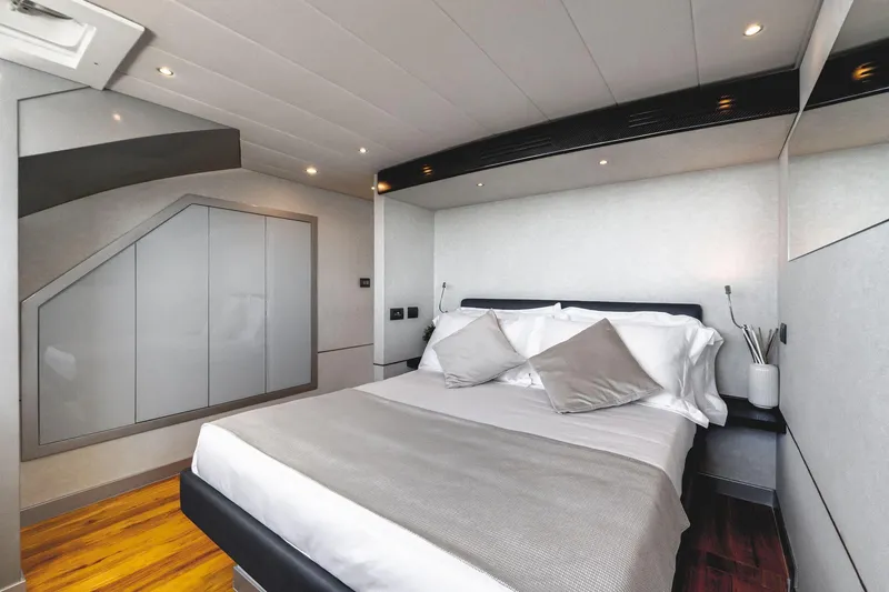 Lyfe At Sea Yacht Photos Pics Luxurious bedroom interior on 2015 Magic Yachts Custom, featuring modern design and elegant bedding.