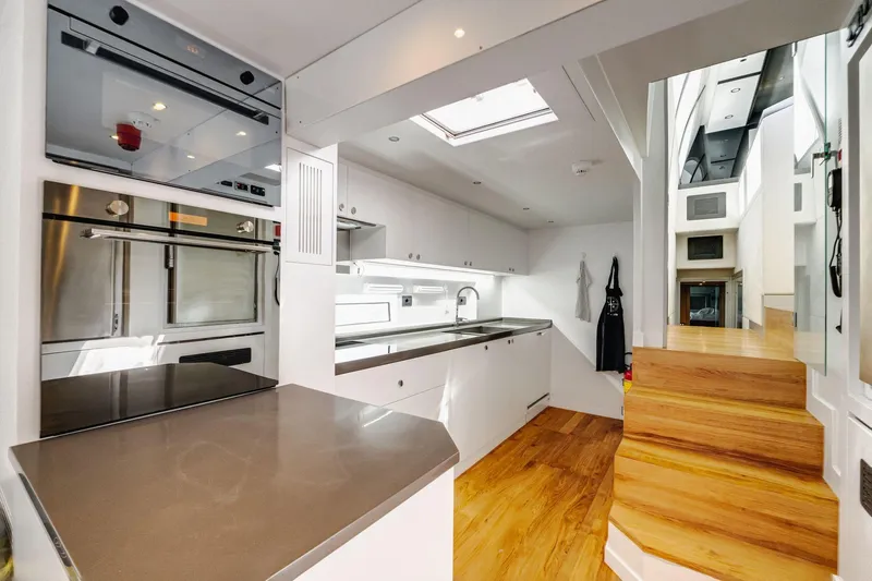 Lyfe At Sea Yacht Photos Pics Modern kitchen interior on 2015 Magic Yachts Custom model, featuring sleek design and wooden flooring.