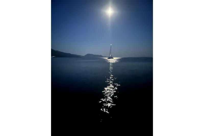  Yacht Photos Pics Sailboat Dufour 530, 2024 model, illuminated by moonlight on calm sea.
