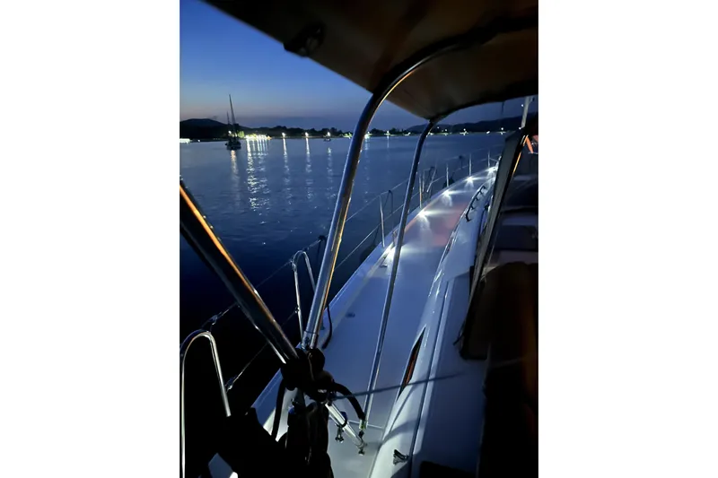  Yacht Photos Pics 2024 Dufour 530 yacht at dusk, illuminated deck, serene waterscape.