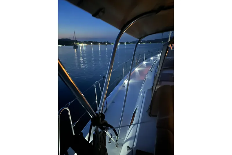  Yacht Photos Pics 2024 Dufour 530 yacht at dusk, illuminated deck, calm waters.