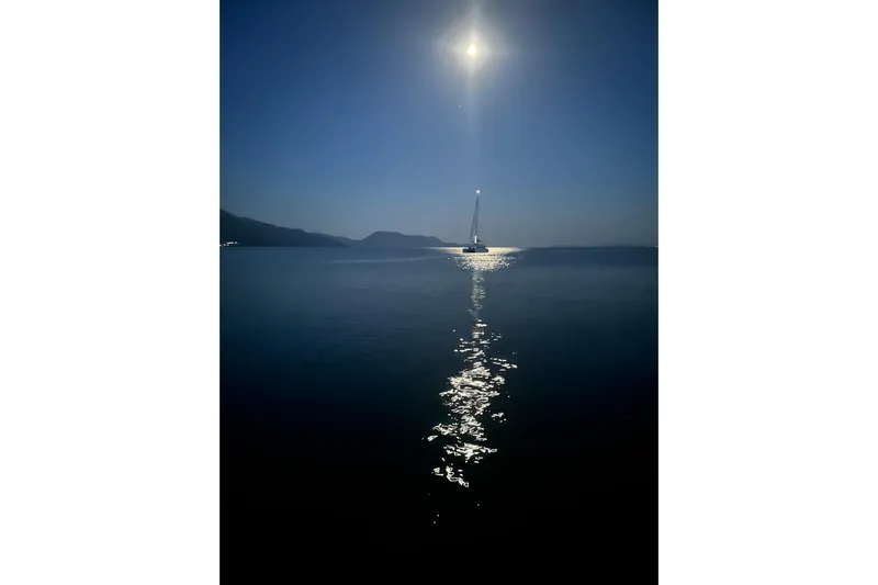  Yacht Photos Pics Sailboat Dufour 530, 2024 model, illuminated by moonlight on calm sea.