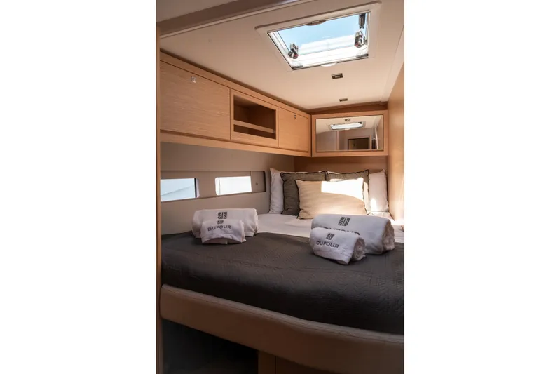  Yacht Photos Pics Luxurious cabin interior of 2024 Dufour 530 yacht with cozy bedding and natural light.