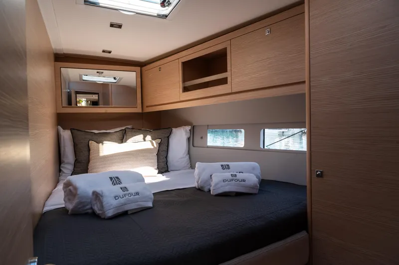  Yacht Photos Pics Luxurious cabin interior of 2024 Dufour 530 yacht with cozy bedding and natural light.