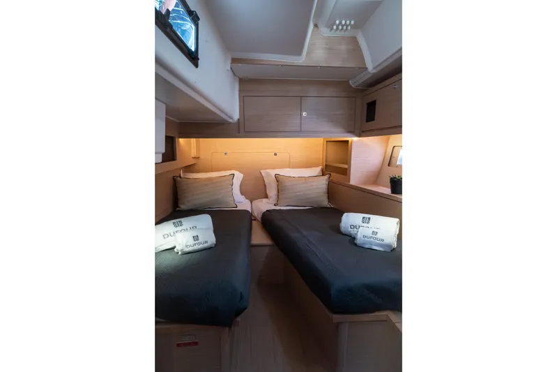  Yacht Photos Pics 2024 Dufour 530 yacht cabin with twin beds, modern design, and cozy lighting.