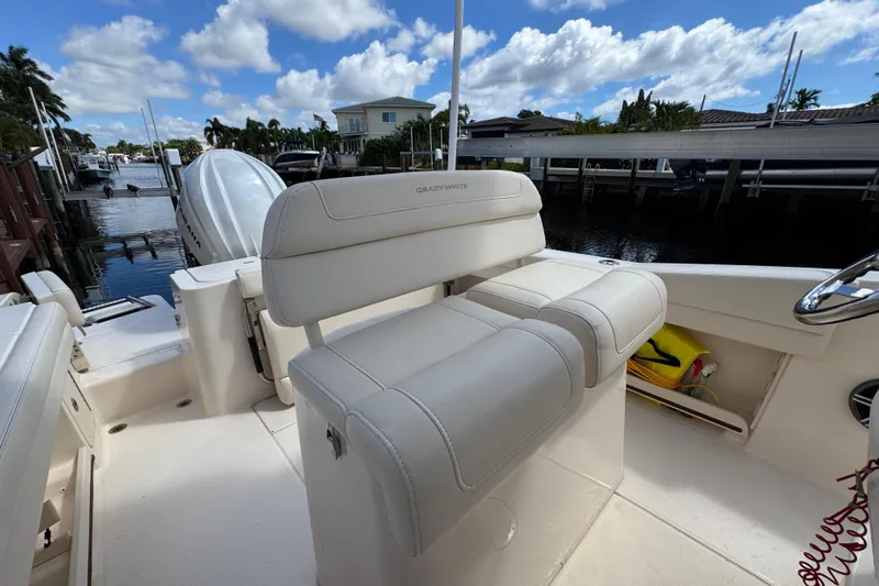  Yacht Photos Pics 2024 Grady-White Fisherman 236 boat interior with white seating, docked by a canal.