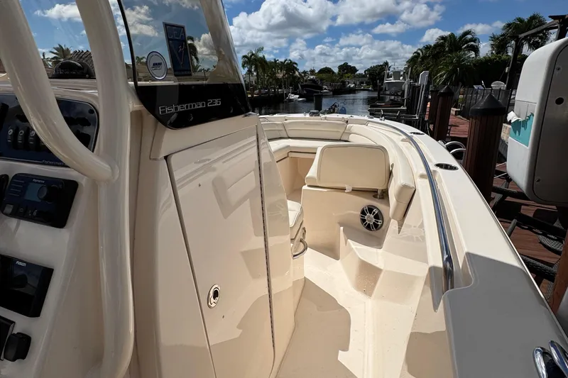  Yacht Photos Pics 2024 Grady-White Fisherman 236 boat interior with console and seating, docked under blue sky.