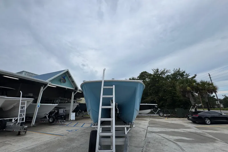  Yacht Photos Pics 2025 Invincible 40 Catamaran on trailer at a boat dealership under cloudy sky.