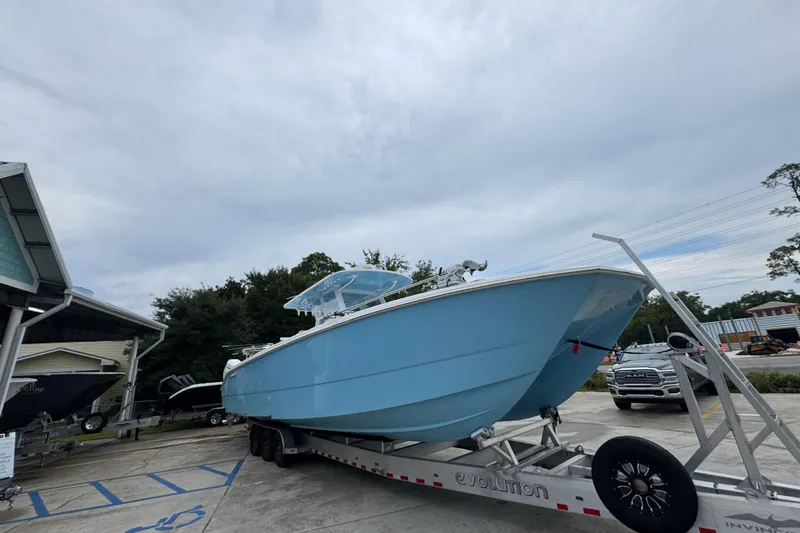  Yacht Photos Pics 2025 Invincible 40 Catamaran in light blue on a trailer, parked outdoors.