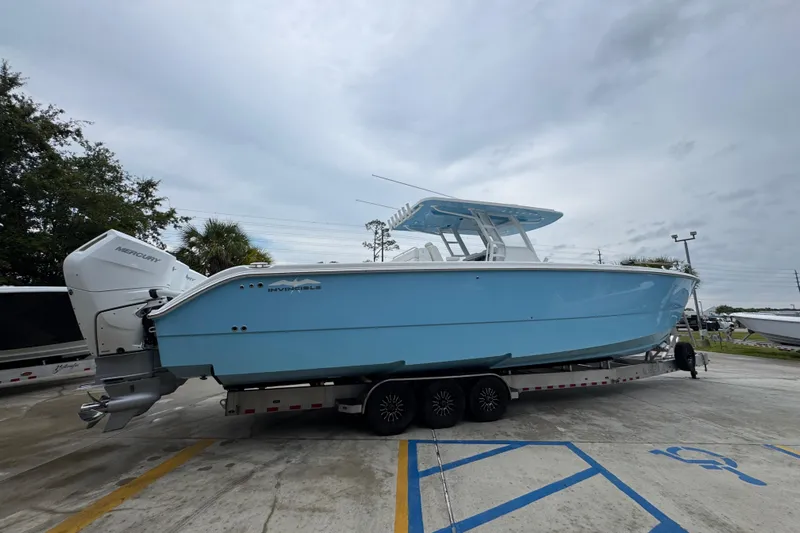  Yacht Photos Pics 2025 Invincible 40 Catamaran in light blue on a trailer, parked outdoors.