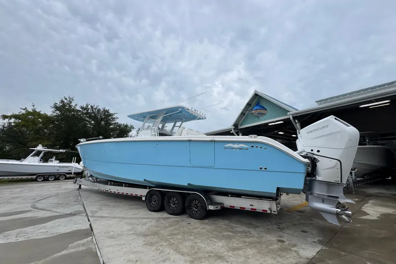  Yacht Photos Pics 2025 Invincible 40 Catamaran in light blue on trailer, parked outdoors.