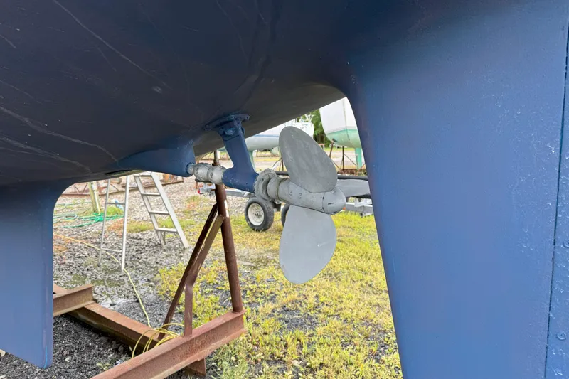 Mer Du Jour Yacht Photos Pics Propeller of 2005 Caliber 40 LRC SE sailboat on dry dock, blue hull visible.
