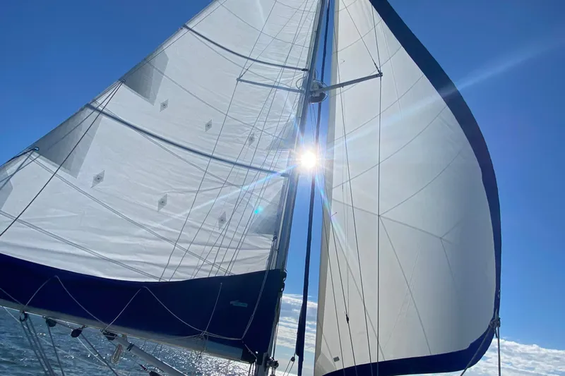 Mer Du Jour Yacht Photos Pics Sailboat Caliber 40 LRC SE 2005 with sunlit sails against a clear blue sky.