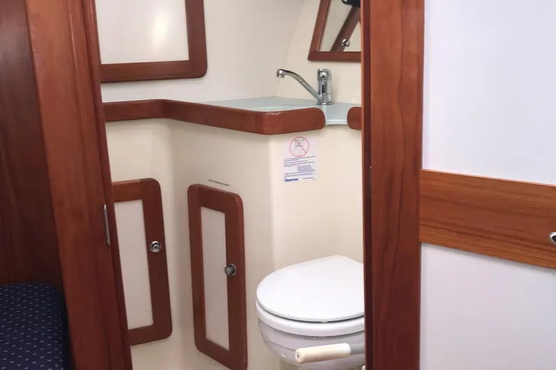 Mer Du Jour Yacht Photos Pics 2005 Caliber 40 LRC SE yacht bathroom with wooden accents and compact design.