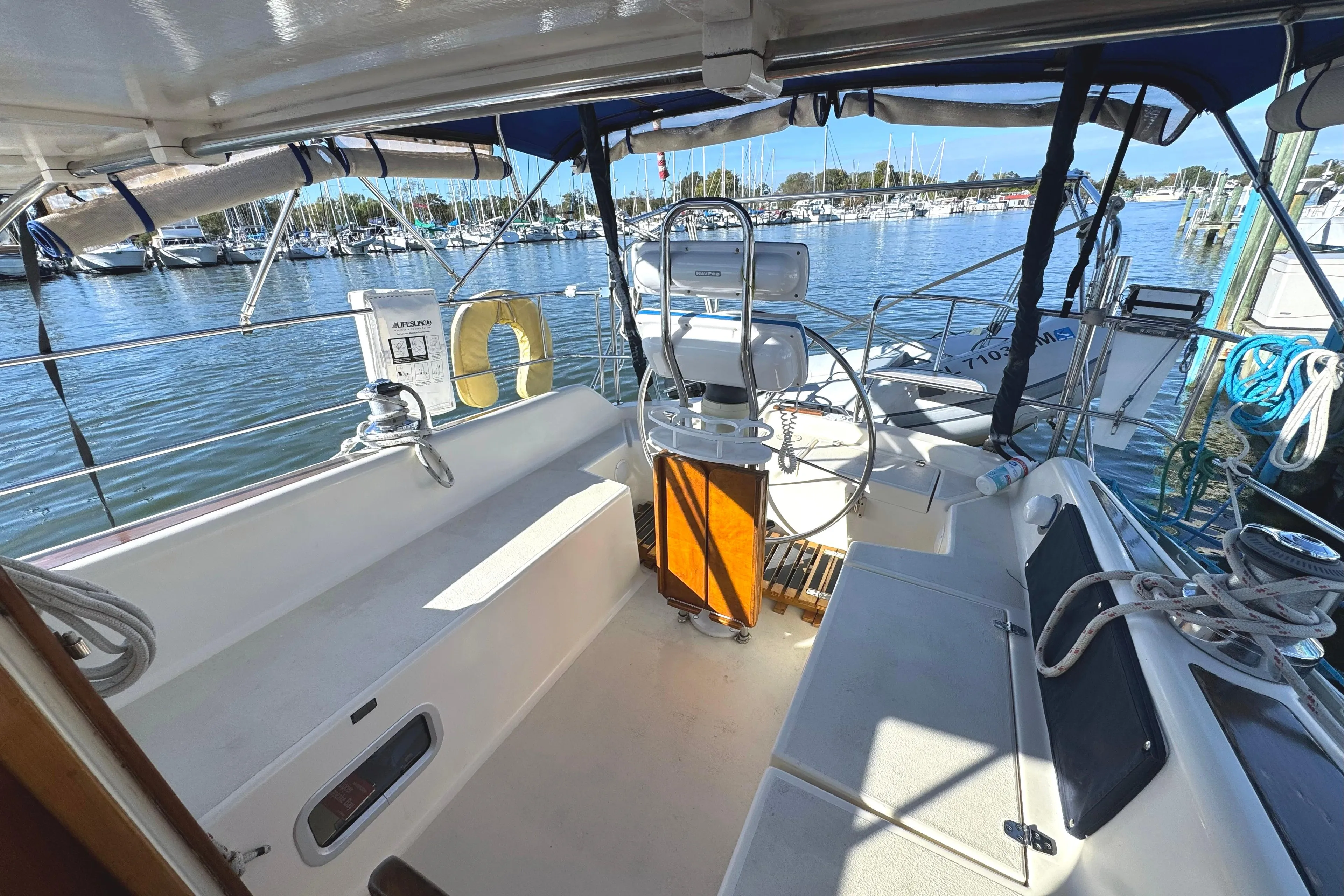 2005 Caliber 40 LRC SE sailboat cockpit with steering wheel, docked at marina.