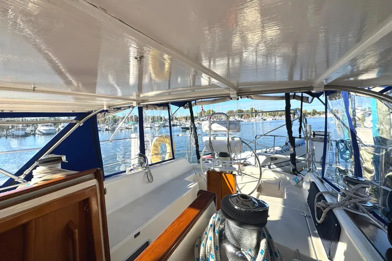 Mer Du Jour Yacht Photos Pics Interior view of 2005 Caliber 40 LRC SE sailboat, featuring spacious cockpit and marina backdrop.