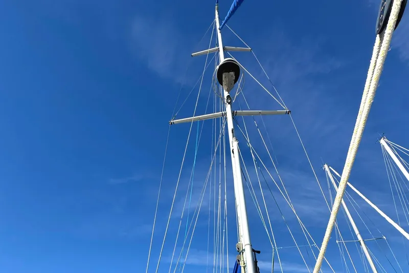 Mer Du Jour Yacht Photos Pics Sailboat mast of 2005 Caliber 40 LRC SE against clear blue sky.