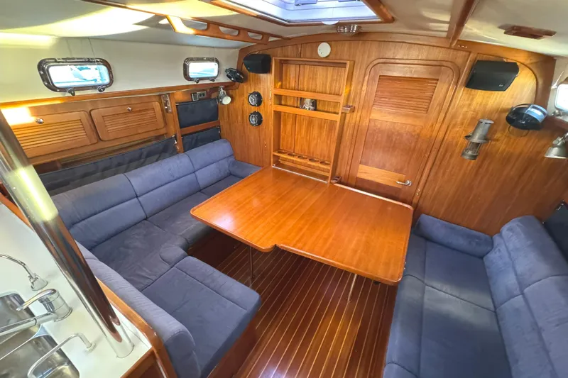 Mer Du Jour Yacht Photos Pics Interior of 2005 Caliber 40 LRC SE yacht with wooden table and blue seating.