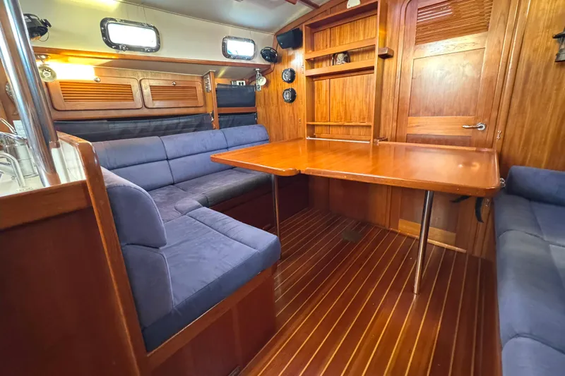 Mer Du Jour Yacht Photos Pics Interior of 2005 Caliber 40 LRC SE yacht with wooden table and blue seating.