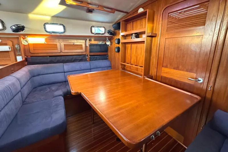 Mer Du Jour Yacht Photos Pics Interior of 2005 Caliber 40 LRC SE yacht with wooden table and blue seating.