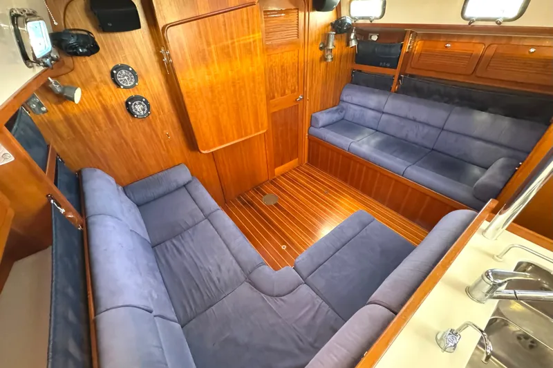 Mer Du Jour Yacht Photos Pics Interior of 2005 Caliber 40 LRC SE yacht with blue seating and wooden paneling.