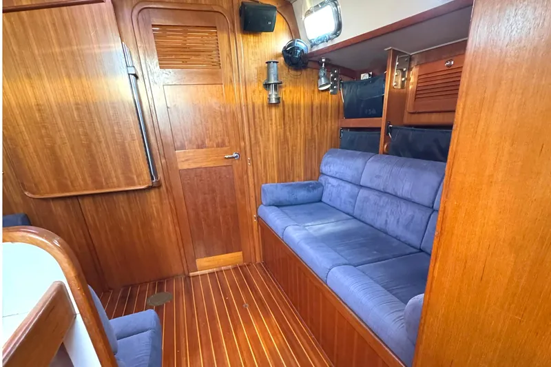 Mer Du Jour Yacht Photos Pics Interior of 2005 Caliber 40 LRC SE yacht with wooden paneling and blue sofa.