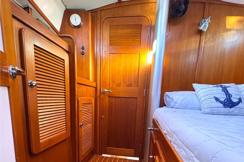 Mer Du Jour Yacht Photos Pics Interior of 2005 Caliber 40 LRC SE yacht with wooden cabinetry and nautical-themed bedding.