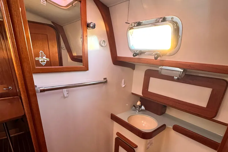 Mer Du Jour Yacht Photos Pics 2005 Caliber 40 LRC SE yacht bathroom with wooden accents and porthole window.
