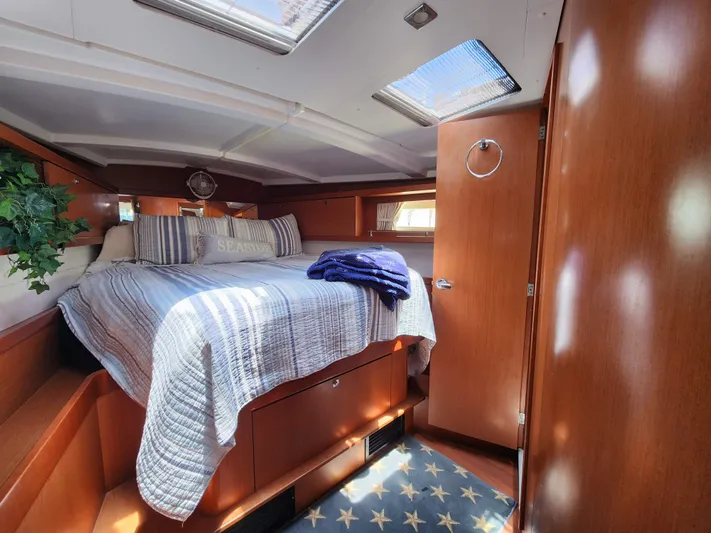 Day One Yacht Photos Pics Cozy cabin interior of 2016 Beneteau Oceanis 45 sailboat with bed and wooden furnishings.