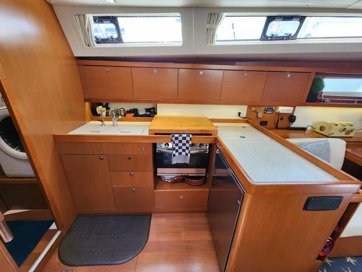 Day One Yacht Photos Pics Interior of 2016 Beneteau Oceanis 45 yacht kitchen with wood cabinetry and modern appliances.