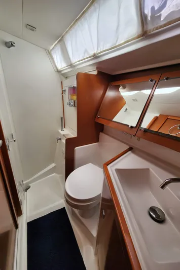 Day One Yacht Photos Pics 2016 Beneteau Oceanis 45 bathroom with shower, sink, and wooden cabinetry.