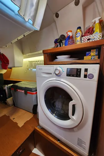Day One Yacht Photos Pics Laundry area on 2016 Beneteau Oceanis 45 yacht with washing machine and storage shelves.