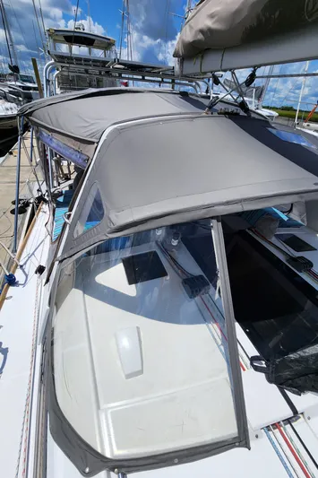Day One Yacht Photos Pics 2016 Beneteau Oceanis 45 sailboat with gray canopy, docked under blue sky.