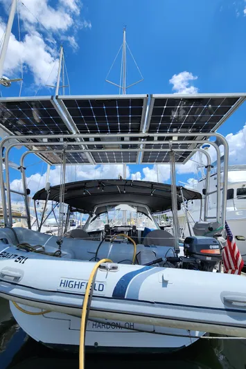 Day One Yacht Photos Pics Beneteau Oceanis 45 sailboat with solar panels and dinghy, 2016 model, docked under blue sky.