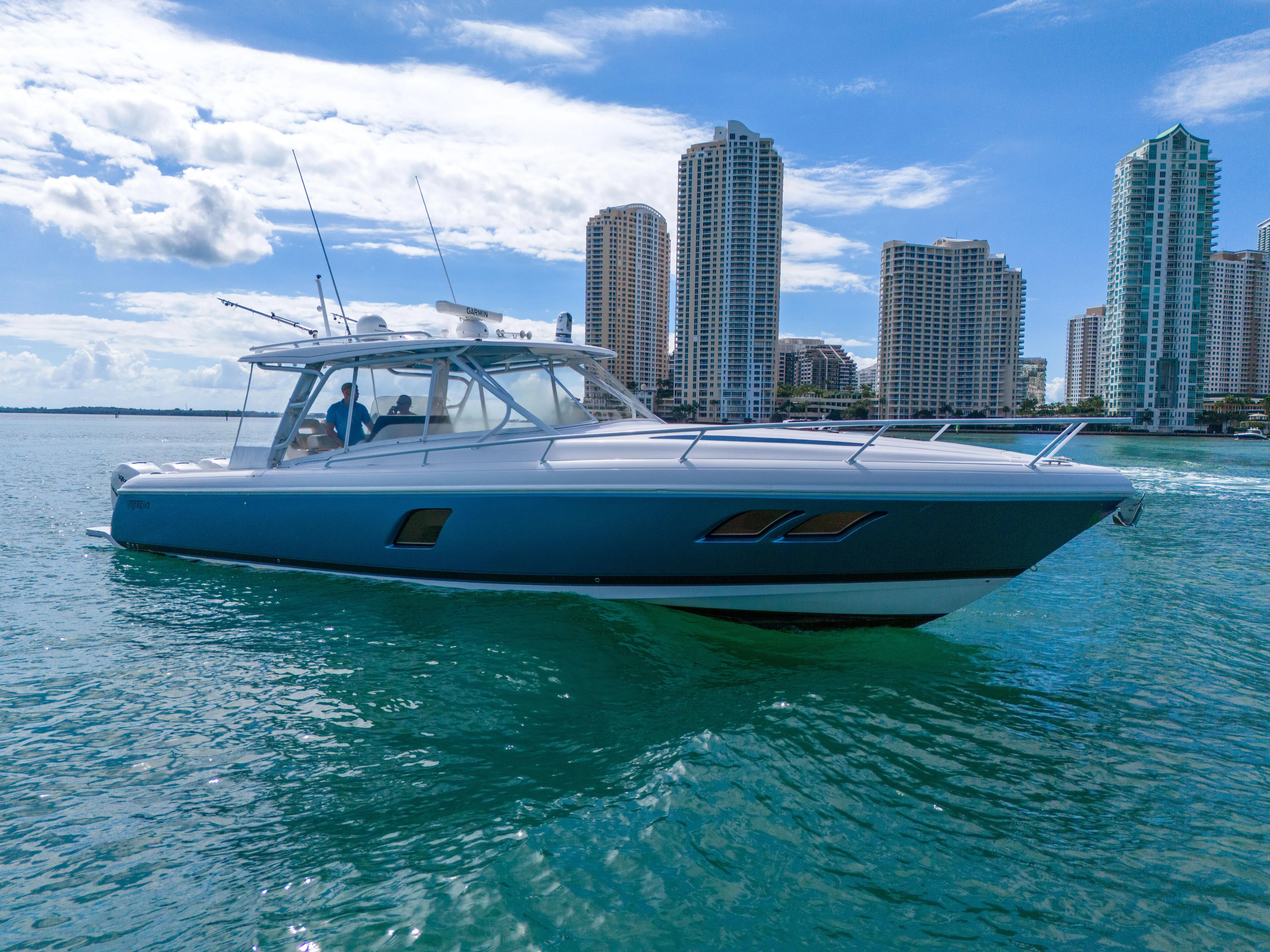  Yacht Photos Pics 2019 Intrepid 407 Cuddy cruising near city skyline on a sunny day.