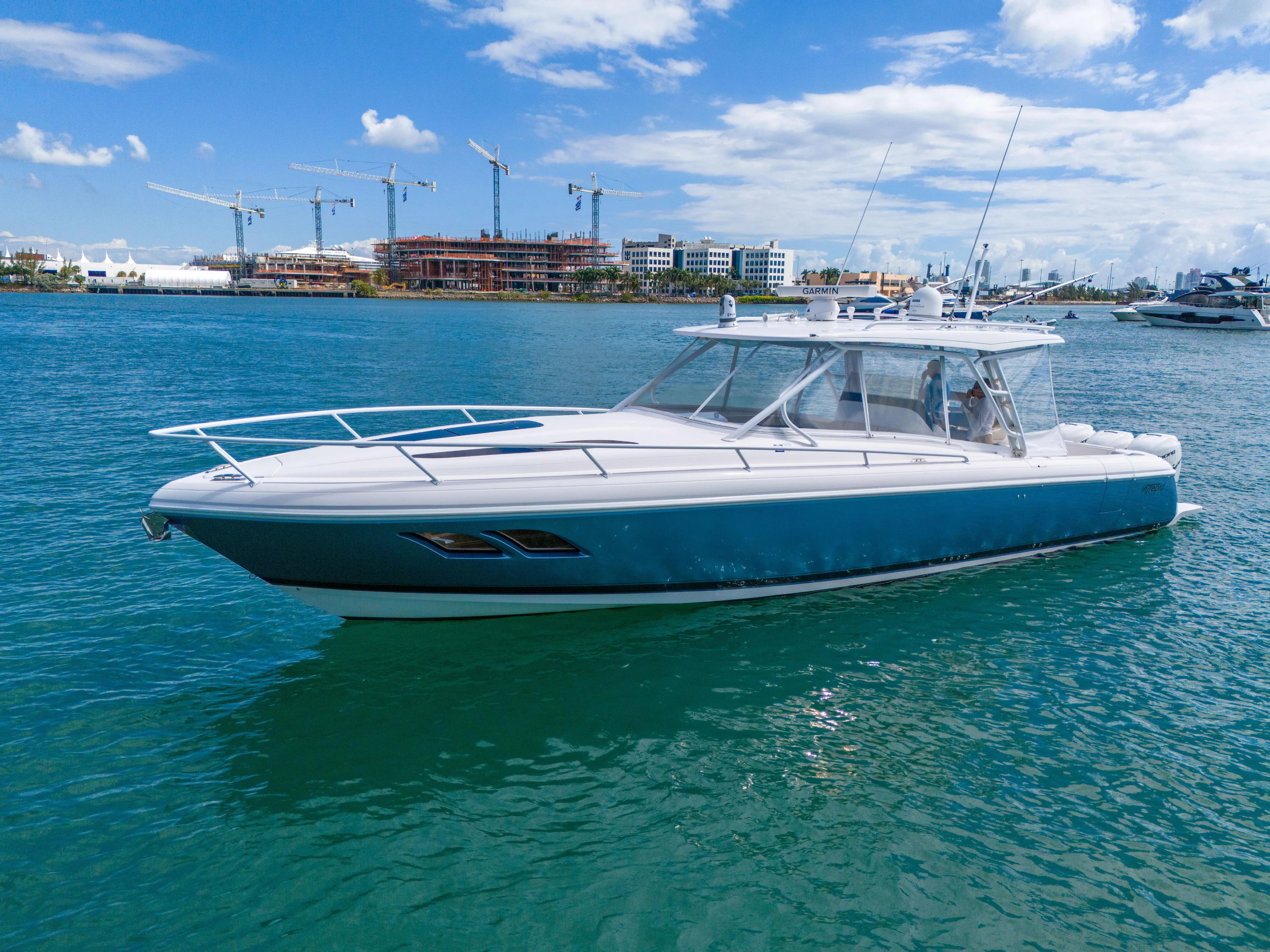  Yacht Photos Pics 2019 Intrepid 407 Cuddy boat on clear blue water, with cityscape background.