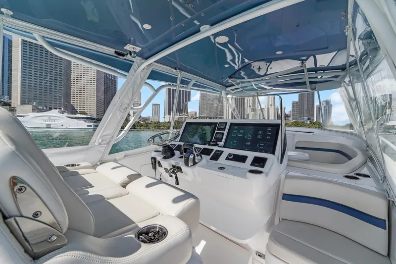  Yacht Photos Pics 2019 Intrepid 407 Cuddy boat interior with modern dashboard, city skyline in background.