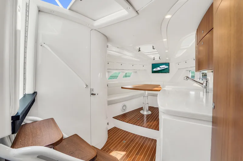  Yacht Photos Pics 2019 Intrepid 407 Cuddy interior with modern design, wooden flooring, and seating area.