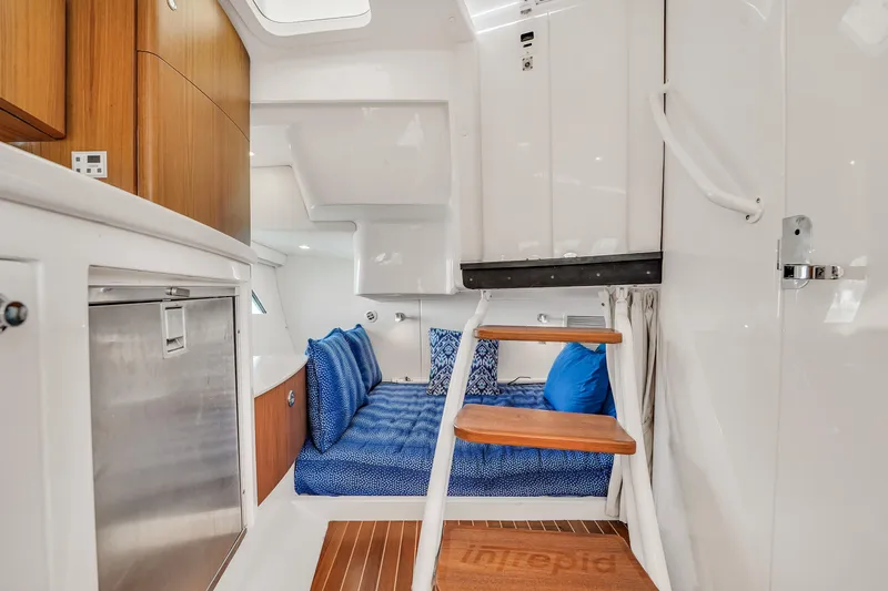  Yacht Photos Pics 2019 Intrepid 407 Cuddy interior with blue seating, wooden accents, and modern design.