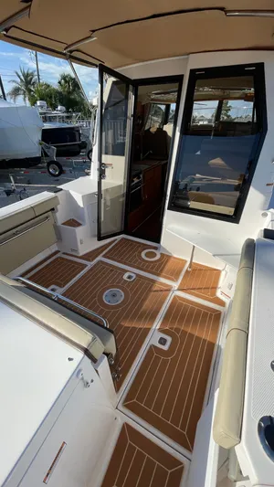  Yacht Photos Pics 2023 Ranger Tugs R-27 boat deck with teak flooring and open cabin door.