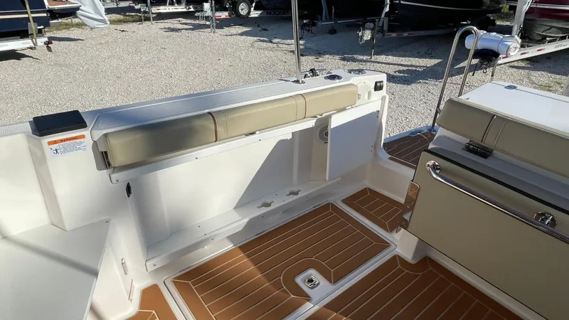  Yacht Photos Pics 2023 Ranger Tugs R-27 boat interior with cushioned seating and wood-patterned flooring.