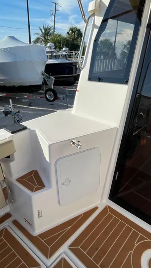  Yacht Photos Pics 2023 Ranger Tugs R-27 boat deck with storage compartment and seating area.