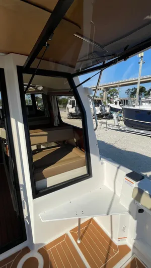  Yacht Photos Pics 2023 Ranger Tugs R-27 interior with seating and table, showcasing modern design and comfort.