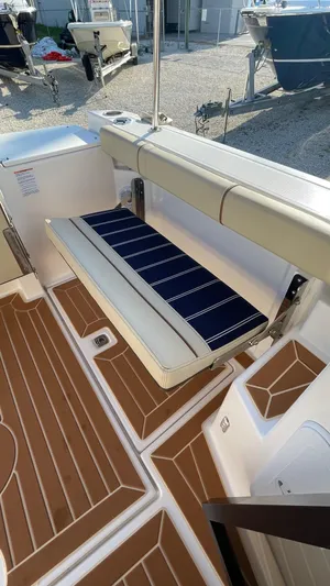  Yacht Photos Pics 2023 Ranger Tugs R-27 boat interior with foldable seating and wood-patterned flooring.