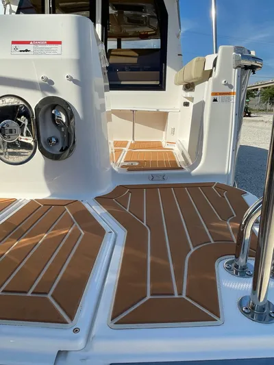  Yacht Photos Pics 2023 Ranger Tugs R-27 boat deck with teak-style flooring and stainless steel fixtures.