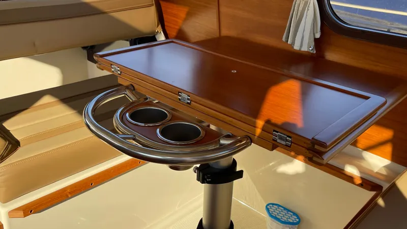 Yacht Photos Pics 2023 Ranger Tugs R-27 interior with wooden table and stainless steel cup holders.