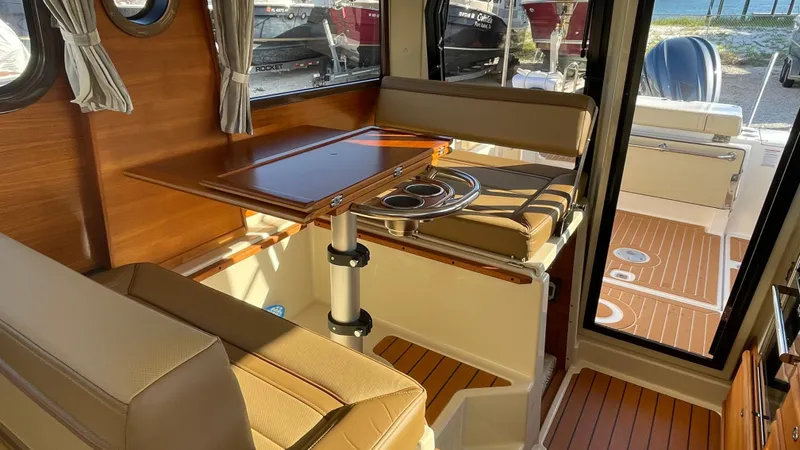  Yacht Photos Pics 2023 Ranger Tugs R-27 interior with wood accents and seating area.