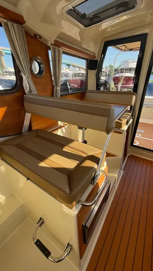  Yacht Photos Pics 2023 Ranger Tugs R-27 interior with wood accents and brown seating.